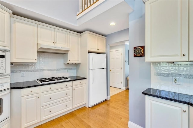 kitchen featuring decorative backsplash, white appliances, light wood-style floors, recessed lighting, and under cabinet range hood