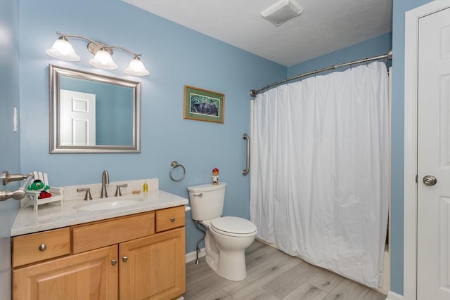 62 Maple St Unit J, Canton, MA 02021 - full bath with wood finished floors, vanity, a shower with curtain, toilet, and baseboards