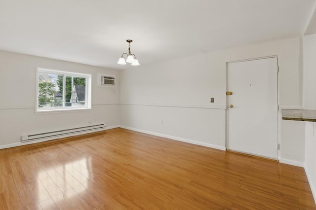 21 Central Ave Unit 30, Everett, MA 02149 - spare room featuring baseboard heating, a chandelier, a wall unit AC, and light wood finished floors