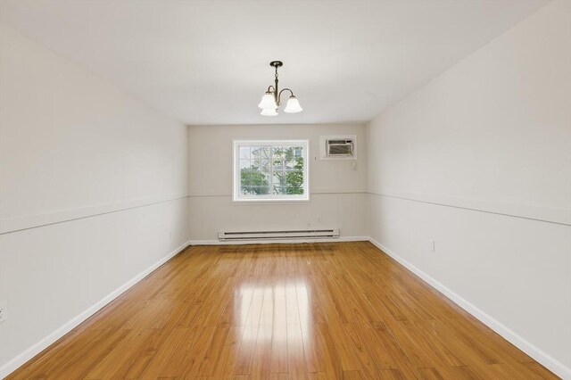 21 Central Ave Unit 30, Everett, MA 02149 - spare room with a baseboard radiator, light wood finished floors, a chandelier, and a wall mounted AC