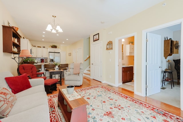 living room featuring a notable chandelier and light wood-type flooring