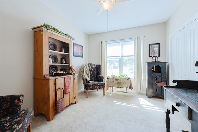 living area featuring ceiling fan and light colored carpet