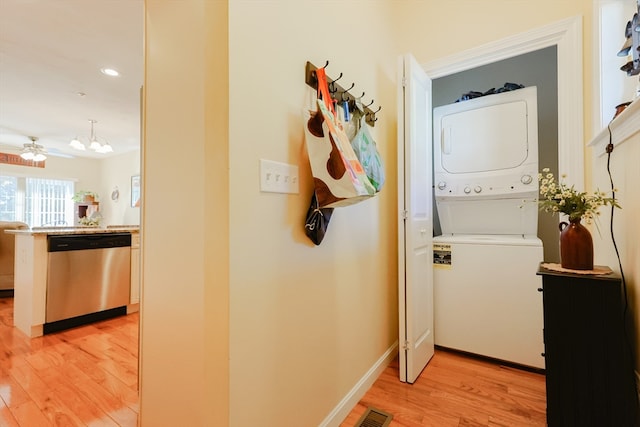 hallway featuring stacked washer / dryer and light hardwood / wood-style floors