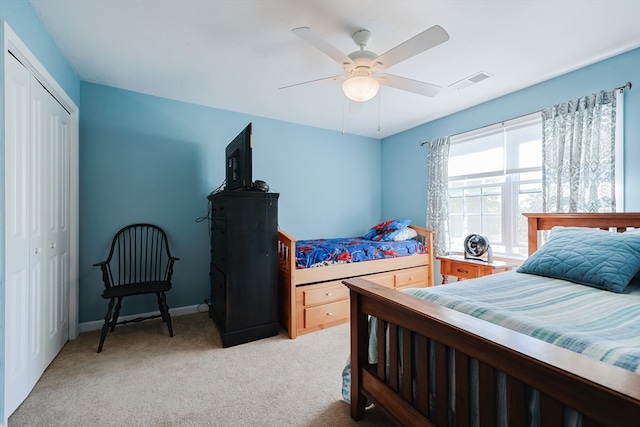 carpeted bedroom with ceiling fan and a closet