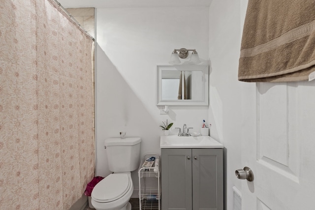 bathroom featuring walk in shower, toilet, and vanity