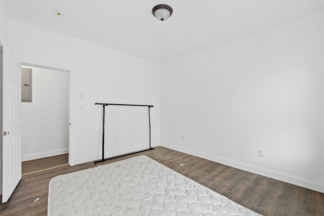 unfurnished bedroom with dark wood-type flooring and electric panel