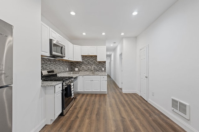 kitchen featuring dark wood-type flooring, white cabinetry, and stainless steel appliances