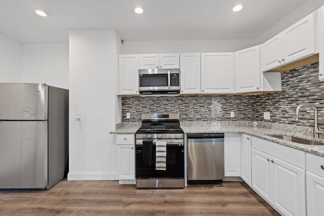 kitchen with dark wood-type flooring, appliances with stainless steel finishes, and white cabinets