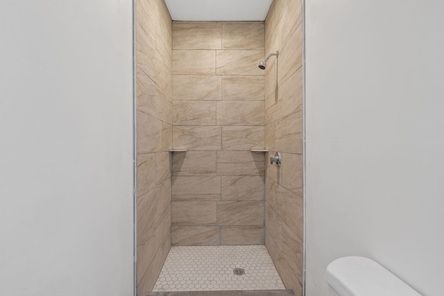 bathroom with toilet and a tile shower