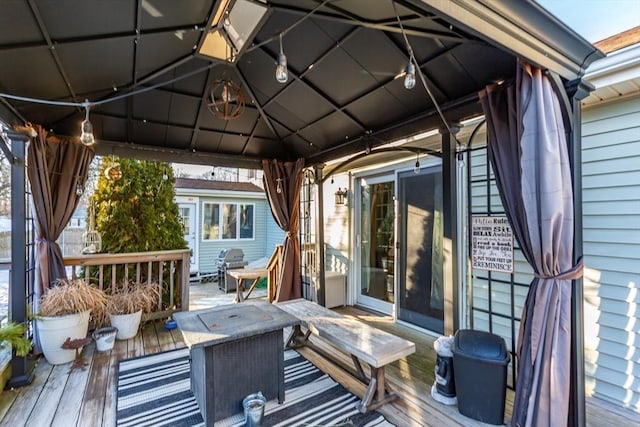 wooden terrace featuring outdoor dining space, area for grilling, and a gazebo