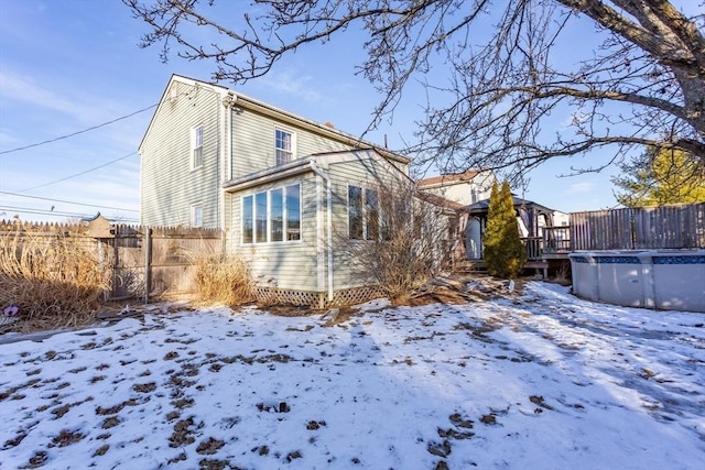 snow covered property featuring a fenced in pool and fence