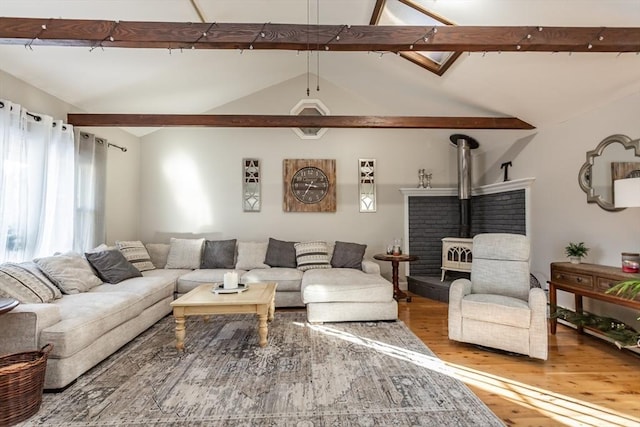 living room with a wood stove, lofted ceiling with beams, and wood finished floors