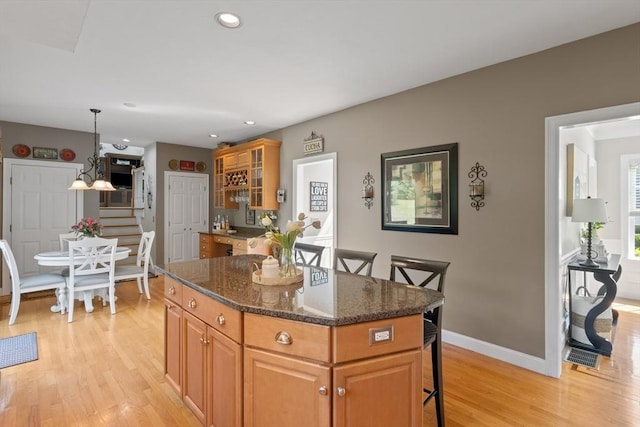 356 Grafton St, Shrewsbury, MA 01545 - kitchen featuring a kitchen bar, light wood finished floors, a kitchen island, dark stone countertops, and recessed lighting