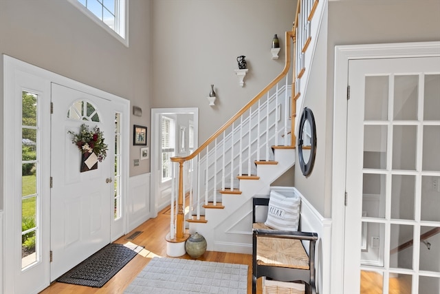 356 Grafton St, Shrewsbury, MA 01545 - foyer entrance featuring stairway, wood finished floors, wainscoting, a high ceiling, and a decorative wall