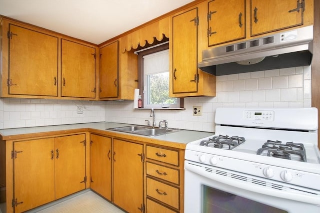 11 Parker St, Mattapoisett, MA 02739 - kitchen with white range with gas stovetop, under cabinet range hood, a sink, light countertops, and decorative backsplash