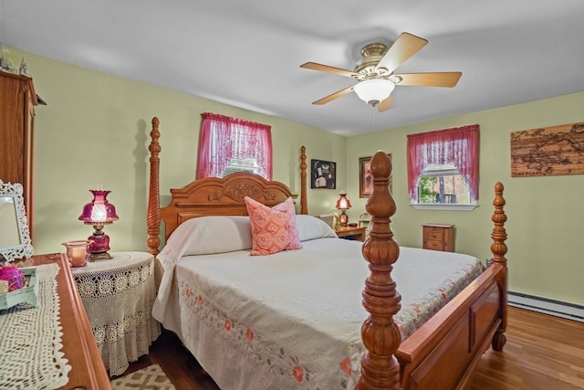 bedroom featuring hardwood / wood-style flooring, a baseboard heating unit, and ceiling fan