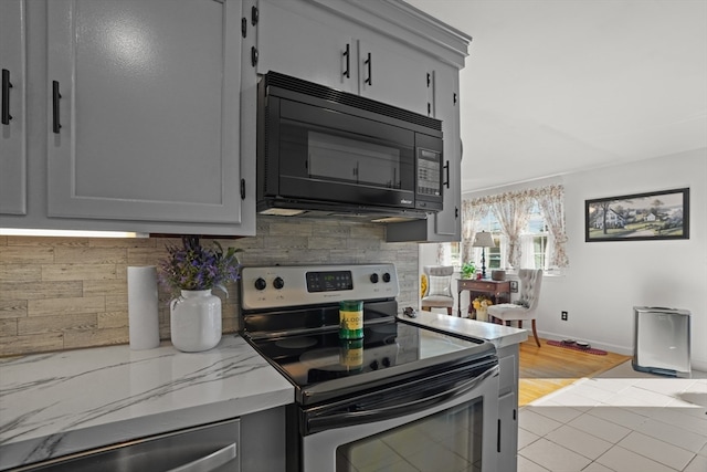 kitchen featuring light tile patterned floors, gray cabinetry, and stainless steel electric stove