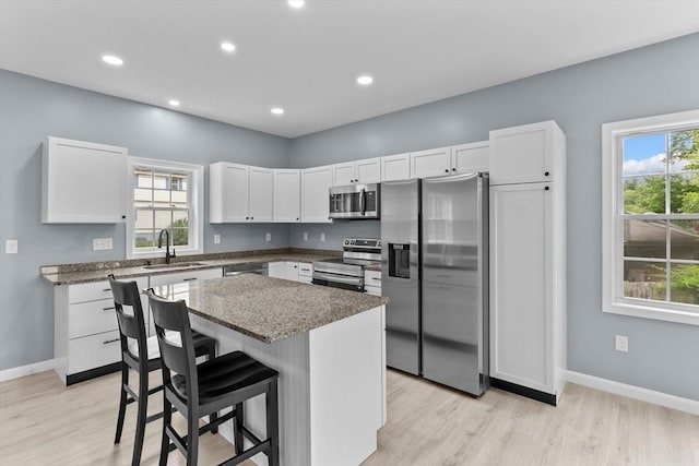 67 Elliott Ave, Dracut, MA 01826 - kitchen featuring stainless steel appliances, white cabinetry, light wood-type flooring, a center island, and recessed lighting