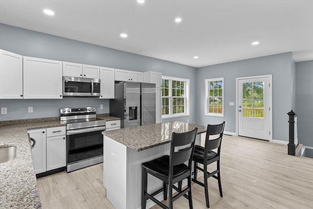 67 Elliott Ave, Dracut, MA 01826 - kitchen with stainless steel appliances, light wood finished floors, a breakfast bar area, white cabinetry, and recessed lighting