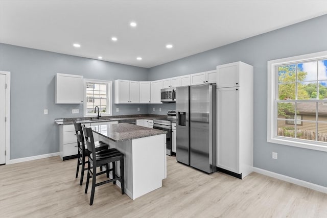 67 Elliott Ave, Dracut, MA 01826 - kitchen featuring stainless steel appliances, healthy amount of natural light, a breakfast bar area, light wood-type flooring, and recessed lighting