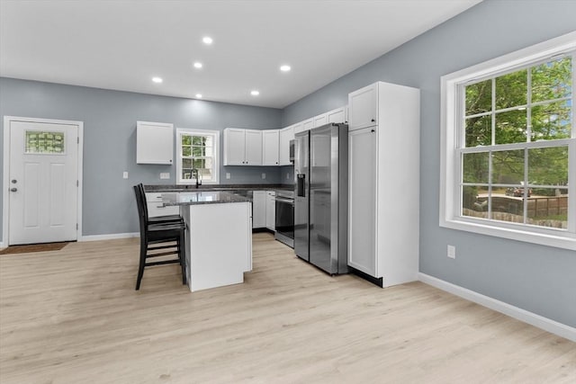 67 Elliott Ave, Dracut, MA 01826 - kitchen with stainless steel appliances, a kitchen island, a kitchen bar, white cabinets, and recessed lighting