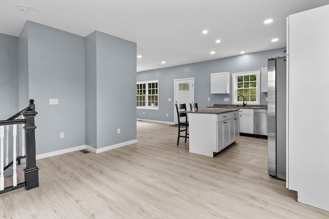 67 Elliott Ave, Dracut, MA 01826 - kitchen with a breakfast bar, white cabinetry, dark countertops, plenty of natural light, and recessed lighting