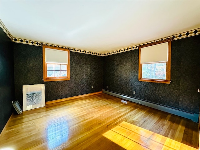 spare room with hardwood / wood-style floors and a baseboard radiator