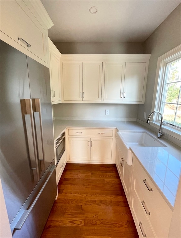 kitchen featuring white cabinets, sink, dark hardwood / wood-style flooring, and stainless steel appliances