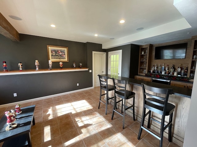 bar with light tile patterned floors and stainless steel dishwasher