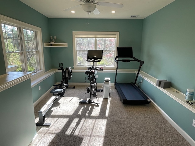 exercise room featuring plenty of natural light, ceiling fan, and light colored carpet