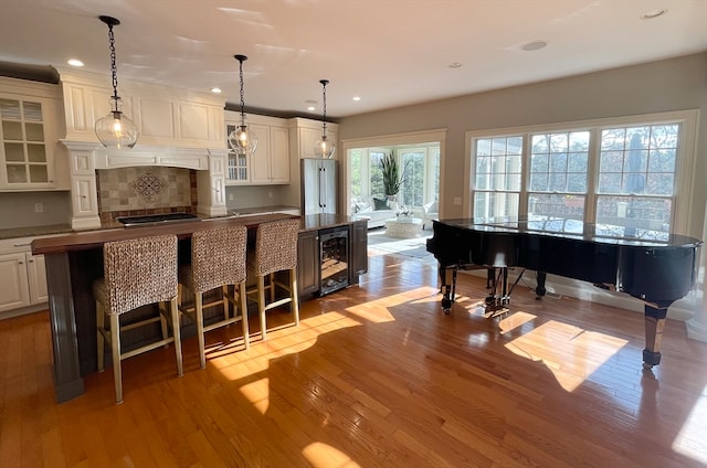 kitchen with a spacious island, hanging light fixtures, and light hardwood / wood-style floors