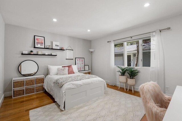 bedroom with wood finished floors, recessed lighting, and baseboards