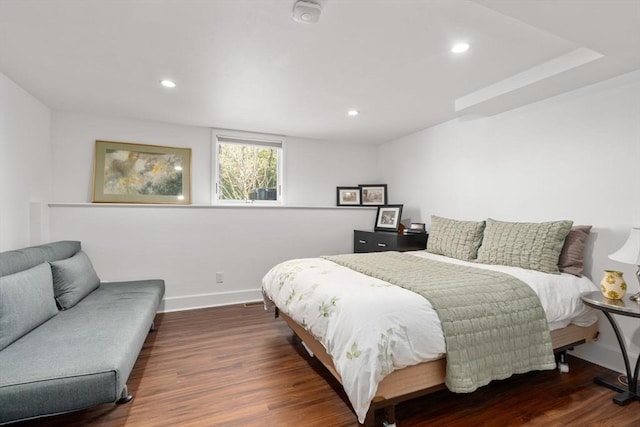 bedroom with baseboards, wood finished floors, and recessed lighting