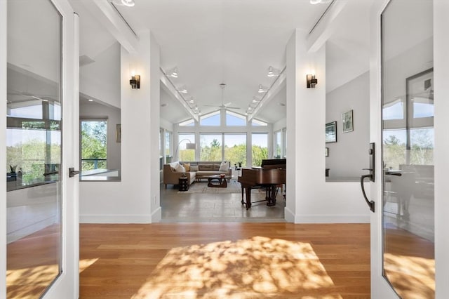 entrance foyer featuring healthy amount of natural light, a ceiling fan, baseboards, and high vaulted ceiling