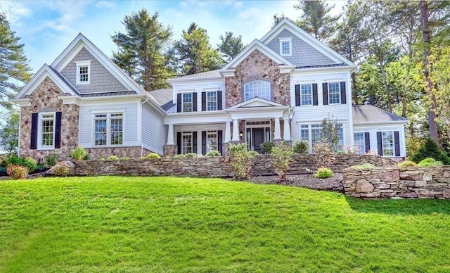 view of front of home featuring stone siding and a front yard