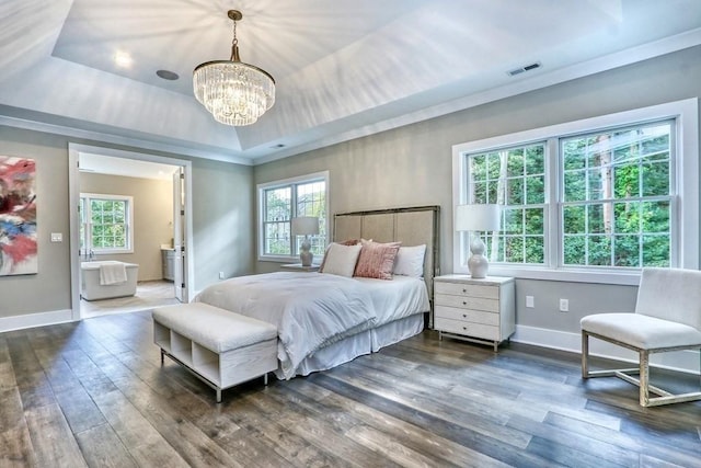 bedroom with a raised ceiling, dark wood-style floors, multiple windows, and a chandelier