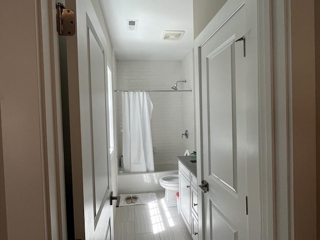 full bath featuring tile patterned flooring, shower / bathtub combination with curtain, and toilet