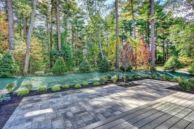 deck featuring a patio area and a wooded view