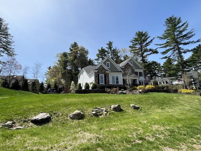 view of front of house with stone siding and a front lawn
