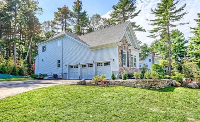 view of home's exterior with an attached garage, driveway, a yard, stone siding, and a shingled roof