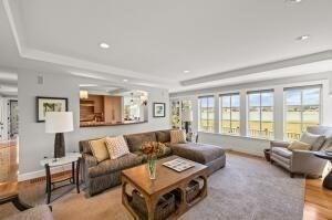 living room with a tray ceiling and light hardwood / wood-style flooring