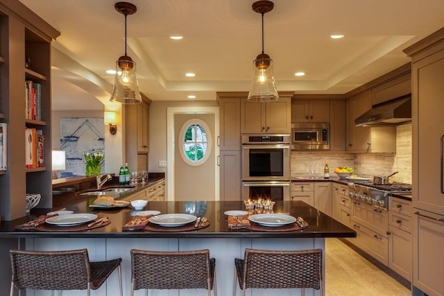 kitchen featuring a kitchen bar, appliances with stainless steel finishes, kitchen peninsula, sink, and range hood