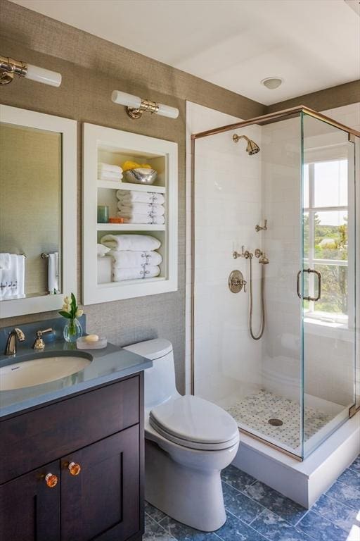 bathroom featuring vanity, toilet, and walk in shower