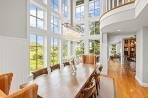 dining space featuring a towering ceiling and light hardwood / wood-style flooring