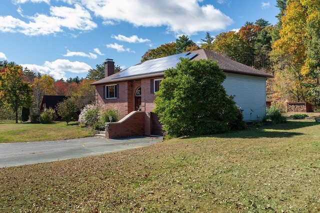 view of front of property featuring a front yard and solar panels