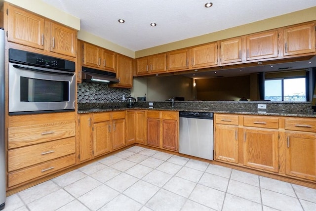 154 Lynnway Unit 511, Lynn, MA 01902 - kitchen featuring stainless steel appliances, under cabinet range hood, backsplash, and brown cabinetry