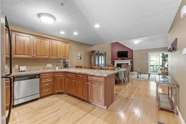 108 Green Briar Rd Unit 108, Fitchburg, MA 01420 - kitchen featuring stainless steel dishwasher, a peninsula, a fireplace, freestanding refrigerator, and light wood-style flooring
