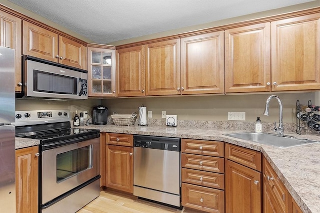 108 Green Briar Rd Unit 108, Fitchburg, MA 01420 - kitchen with appliances with stainless steel finishes, a sink, light wood-type flooring, light countertops, and glass insert cabinets