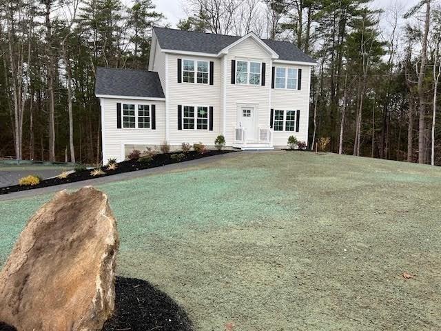 colonial-style house featuring a front yard