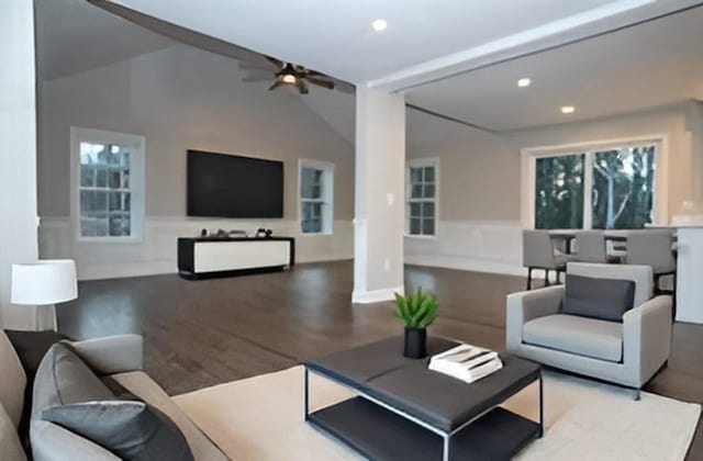 living room featuring ceiling fan, wood-type flooring, and vaulted ceiling